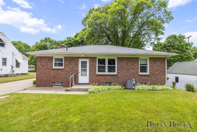 1665 7th St NW, Grand Rapids, MI 49504 - view of front of home with a front lawn, brick siding, a patio, and a chimney
