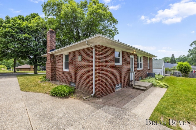 1665 7th St NW, Grand Rapids, MI 49504 - view of side of property featuring a lawn, a chimney, and brick siding