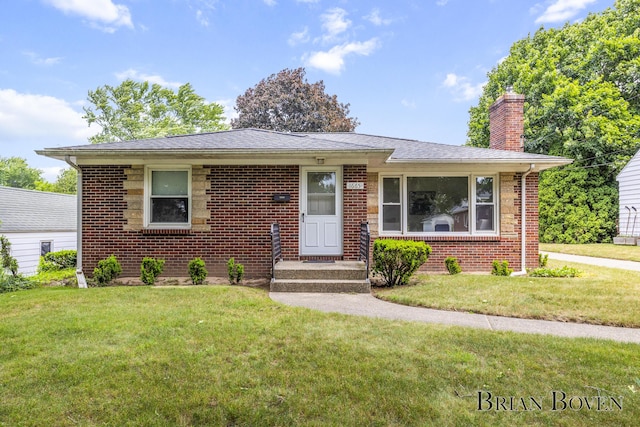 1665 7th St NW, Grand Rapids, MI 49504 - bungalow-style house featuring a chimney, brick siding, and a front yard