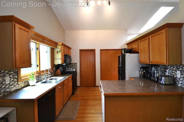10010 Orchard Ridge Ct, Holly, MI 48442 - kitchen featuring black appliances, tasteful backsplash, light wood-style floors, lofted ceiling, and a peninsula