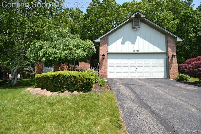 10010 Orchard Ridge Ct, Holly, MI 48442 - view of front of house with driveway, an attached garage, brick siding, and a front lawn