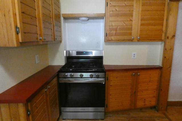 552 W Main St, Niles, MI 49120 - kitchen featuring stainless steel gas stove, brown cabinets, and dark countertops