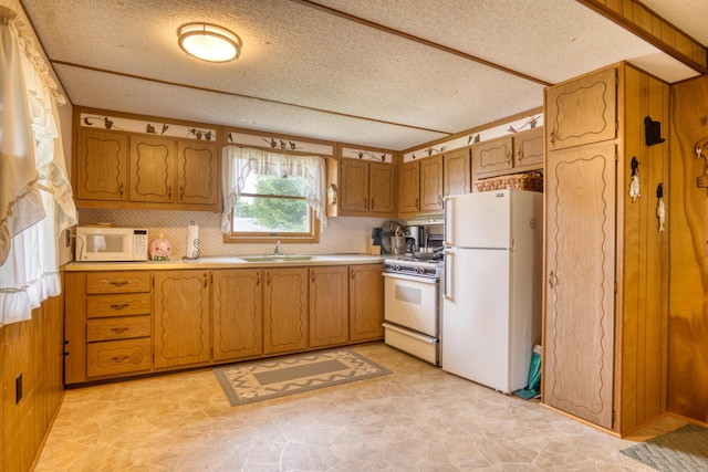 8182 Hardy Dr, Newaygo, MI 49337 - kitchen featuring white appliances, brown cabinetry, a textured ceiling, light countertops, and decorative backsplash