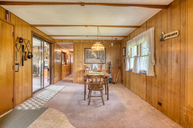 8182 Hardy Dr, Newaygo, MI 49337 - carpeted dining area with wood walls and beam ceiling
