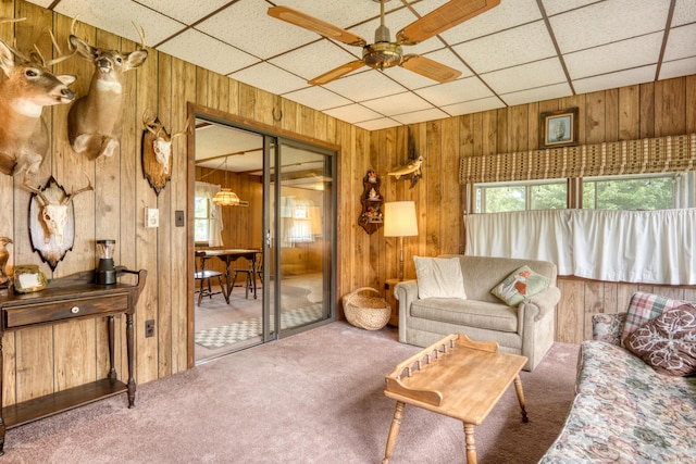 8182 Hardy Dr, Newaygo, MI 49337 - living area with wooden walls, carpet, ceiling fan, and a drop ceiling