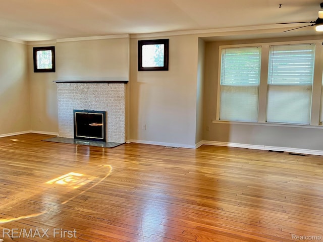 256 Withington St, Ferndale, MI 48220 - unfurnished living room featuring ceiling fan, hardwood / wood-style floors, ornamental molding, and a fireplace