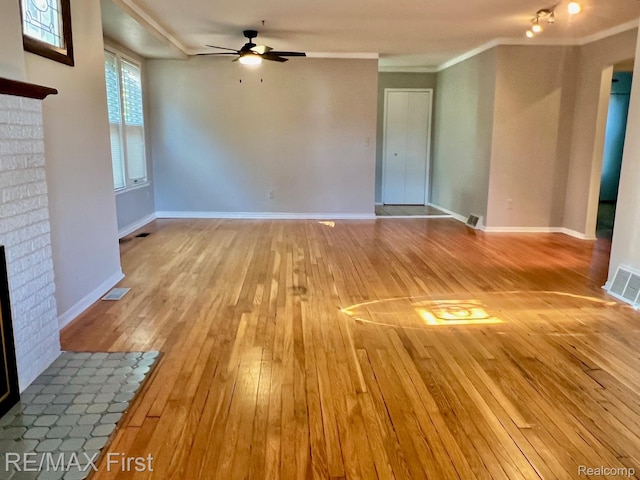 256 Withington St, Ferndale, MI 48220 - unfurnished living room with wood-type flooring, ceiling fan, a fireplace, and crown molding