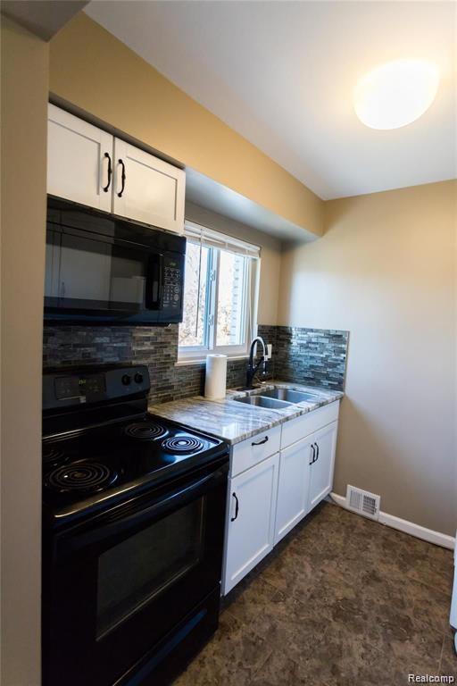 4030 W 13 Mile Rd Unit 3, Royal Oak, MI 48073 - kitchen featuring black appliances, light stone counters, decorative backsplash, and white cabinetry