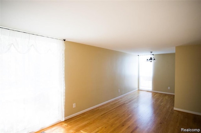 4030 W 13 Mile Rd Unit 3, Royal Oak, MI 48073 - empty room with light wood-style floors and a chandelier