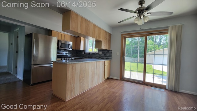 8544 Russell St, Shelby Twp, MI 48317 - kitchen featuring appliances with stainless steel finishes, a peninsula, dark wood-style floors, and decorative backsplash