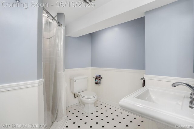 11 Sylvan Ave, Pleasant Ridge, MI 48069 - bathroom with a wainscoted wall and a shower with shower curtain