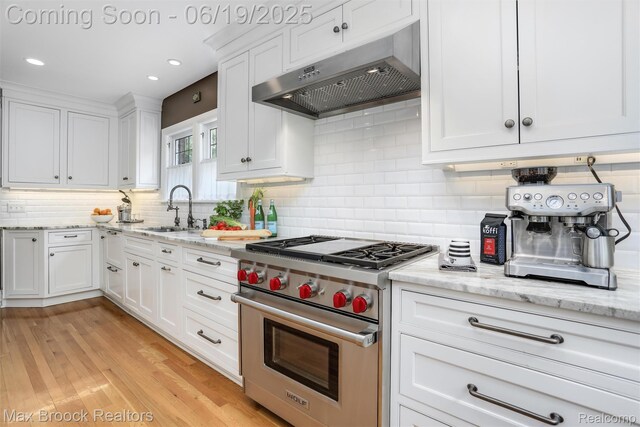 11 Sylvan Ave, Pleasant Ridge, MI 48069 - kitchen featuring designer stove, range hood, white cabinets, backsplash, and light stone counters
