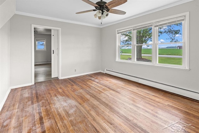 490 W Wilder Rd, Auburn, MI 48611 - spare room with baseboard heating, plenty of natural light, wood finished floors, and ornamental molding
