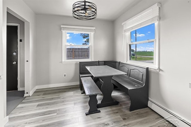 490 W Wilder Rd, Auburn, MI 48611 - dining area featuring a baseboard heating unit, plenty of natural light, and light wood-style floors