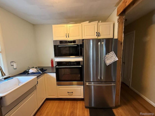 11311 Tecumseh, Redford, MI 48239 - kitchen with appliances with stainless steel finishes, light wood-style floors, white cabinetry, and dark countertops