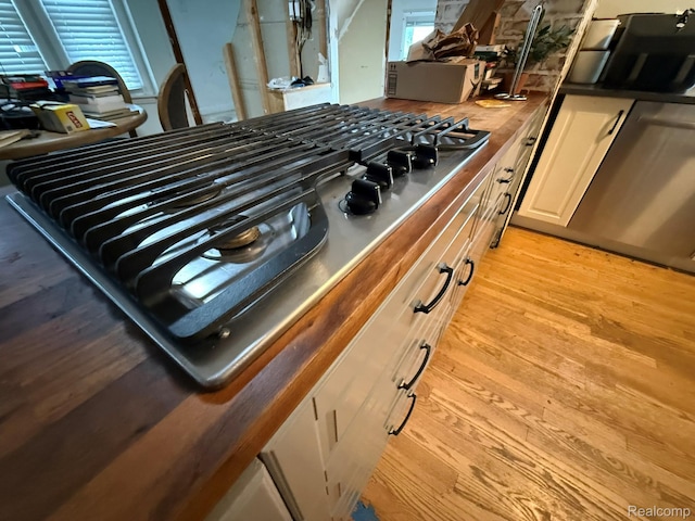 11311 Tecumseh, Redford, MI 48239 - kitchen view of stainless steel gas cooktop, light wood-style floors, butcher block counters, and white cabinetry