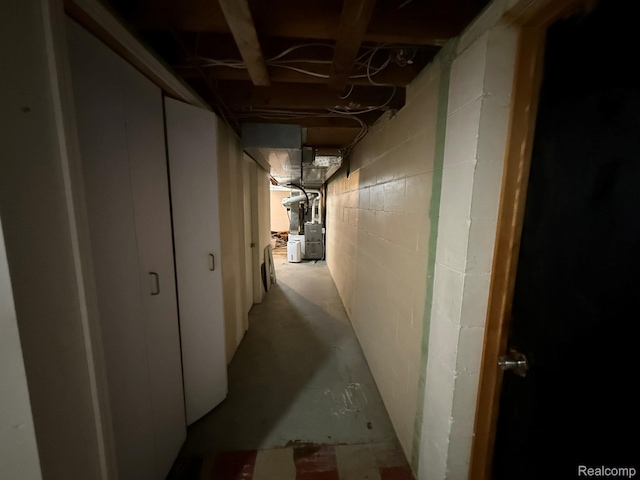 11311 Tecumseh, Redford, MI 48239 - hallway with unfinished concrete flooring, heating unit, and concrete block wall