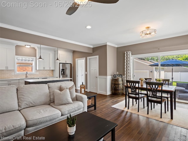 2213 Beverly Blvd, Berkley, MI 48072 - living area with ceiling fan, crown molding, dark wood finished floors, plenty of natural light, and a wainscoted wall