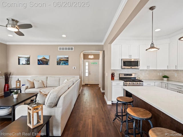 2213 Beverly Blvd, Berkley, MI 48072 - living area with dark wood finished floors, ceiling fan, crown molding, arched walkways, and recessed lighting