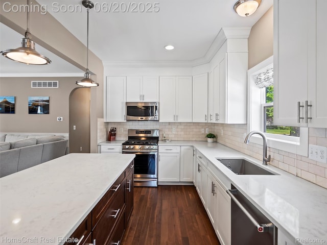 2213 Beverly Blvd, Berkley, MI 48072 - kitchen featuring stainless steel appliances, open floor plan, dark wood-style flooring, ornamental molding, and light stone countertops