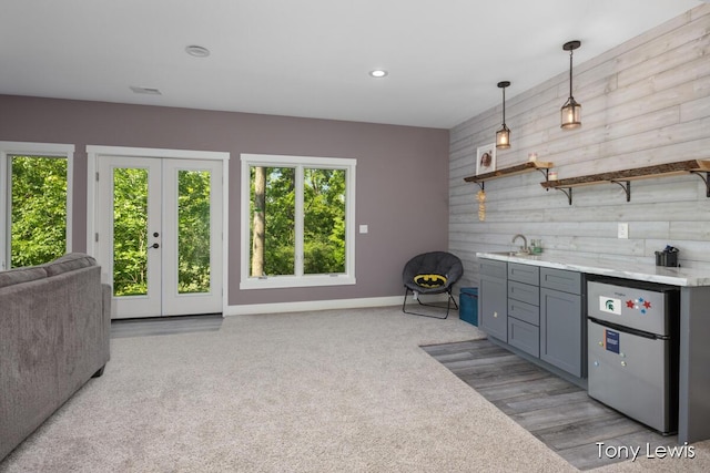 2331 Deer Trail Dr NE, Grand Rapids, MI 49505 - kitchen with freestanding refrigerator, wooden walls, french doors, open floor plan, and an accent wall