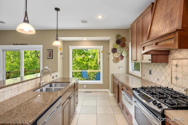 2331 Deer Trail Dr NE, Grand Rapids, MI 49505 - kitchen featuring appliances with stainless steel finishes, premium range hood, light tile patterned floors, brown cabinetry, and backsplash