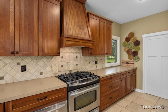 2331 Deer Trail Dr NE, Grand Rapids, MI 49505 - kitchen with stainless steel gas range, premium range hood, decorative backsplash, light countertops, and brown cabinetry
