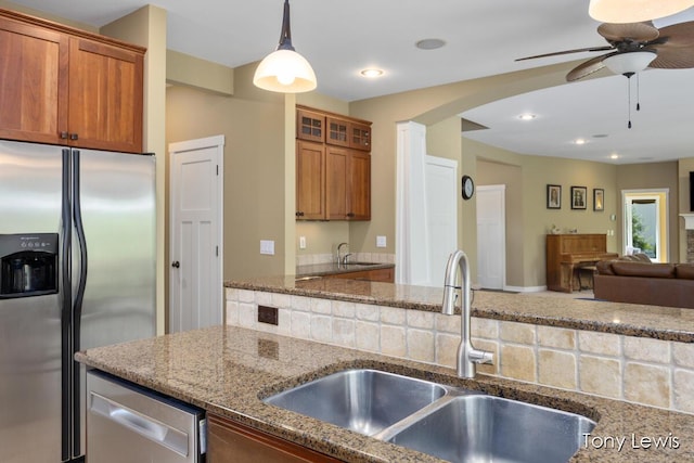 2331 Deer Trail Dr NE, Grand Rapids, MI 49505 - kitchen with appliances with stainless steel finishes, ceiling fan, brown cabinetry, and stone counters