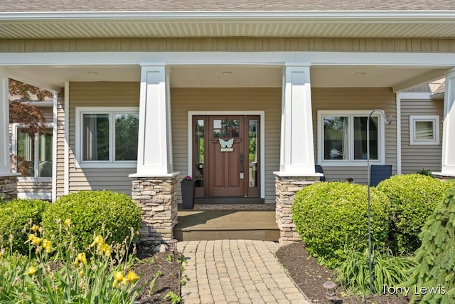 2331 Deer Trail Dr NE, Grand Rapids, MI 49505 - doorway to property featuring a shingled roof, covered porch, and stone siding
