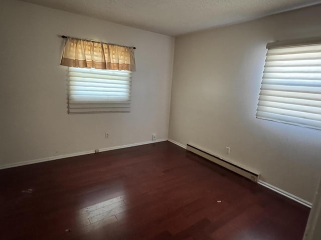 2456 Kurt Rd, Benton Harbor, MI 49022 - unfurnished room featuring a baseboard heating unit, wood finished floors, and a textured ceiling