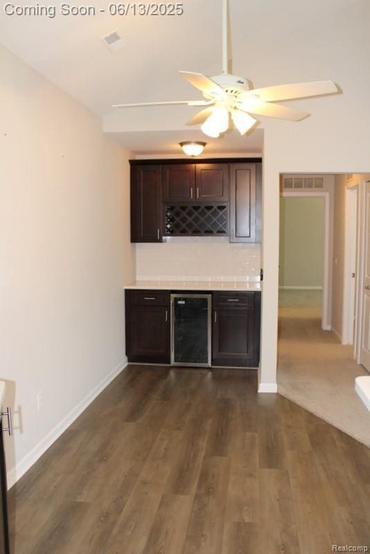 23413 Williamsburg Cir Unit 12, Woodhaven, MI 48183 - indoor dry bar featuring wine cooler, ceiling fan, and dark wood-style flooring