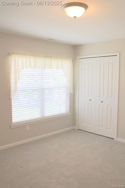 23413 Williamsburg Cir Unit 12, Woodhaven, MI 48183 - unfurnished bedroom with light carpet and a closet