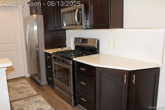 23413 Williamsburg Cir Unit 12, Woodhaven, MI 48183 - kitchen with stainless steel appliances, decorative backsplash, wood finished floors, dark brown cabinetry, and light countertops