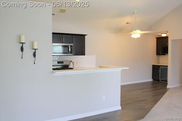 23413 Williamsburg Cir Unit 12, Woodhaven, MI 48183 - kitchen with stainless steel microwave, stove, decorative backsplash, ceiling fan, and dark wood-style floors