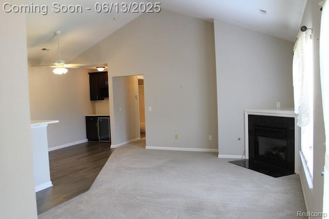 23413 Williamsburg Cir Unit 12, Woodhaven, MI 48183 - unfurnished living room with a glass covered fireplace, a ceiling fan, high vaulted ceiling, and carpet floors