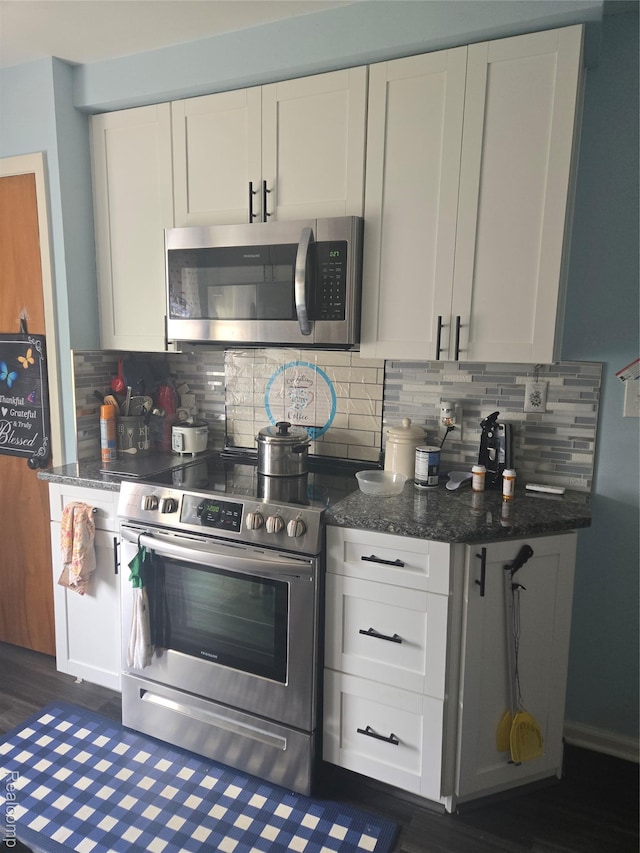 22612 Lyndon St, Detroit, MI 48223 - kitchen featuring appliances with stainless steel finishes, decorative backsplash, white cabinetry, and dark wood-type flooring