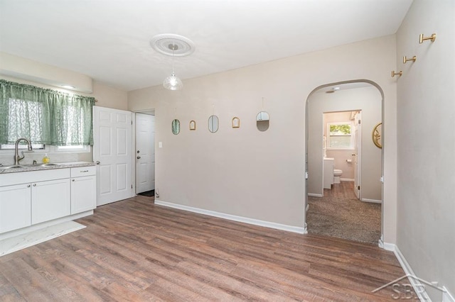 1601 S Monroe St, Bay City, MI 48708 - kitchen with white cabinets, light countertops, arched walkways, and wood finished floors
