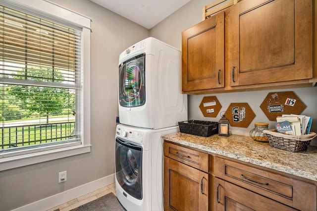 2753 Colton Dr, Berrien Springs, MI 49103 - washroom featuring stacked washer and clothes dryer, cabinet space, plenty of natural light, and tile patterned floors