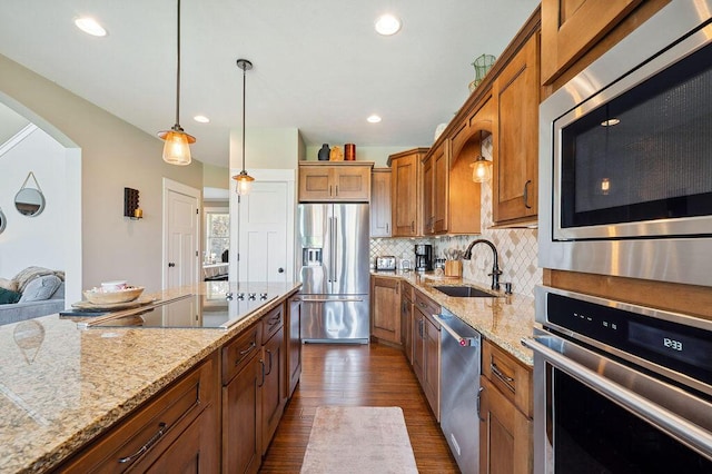 2753 Colton Dr, Berrien Springs, MI 49103 - kitchen featuring appliances with stainless steel finishes, brown cabinets, decorative backsplash, dark wood-style flooring, and arched walkways