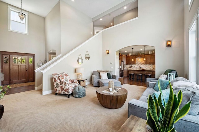 2753 Colton Dr, Berrien Springs, MI 49103 - carpeted living room with a high ceiling, arched walkways, stairway, and recessed lighting