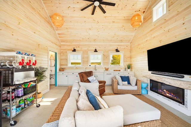 2753 Colton Dr, Berrien Springs, MI 49103 - living area with vaulted ceiling, wooden walls, ceiling fan, wood ceiling, and a glass covered fireplace