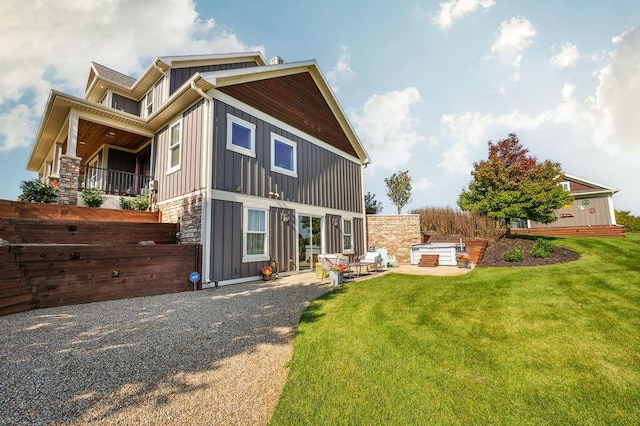 2753 Colton Dr, Berrien Springs, MI 49103 - view of front of house featuring board and batten siding, a patio, a front yard, and a balcony