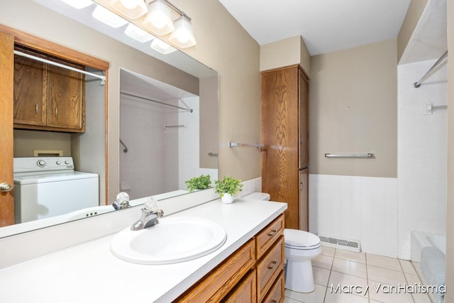 1861 Elizabeth Ln E, Jenison, MI 49428 - bathroom featuring washer / dryer, vanity, tile patterned flooring, bathing tub / shower combination, and wainscoting
