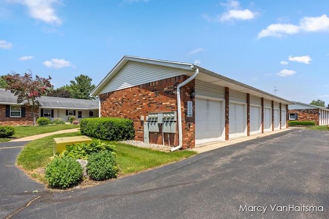 1861 Elizabeth Ln E, Jenison, MI 49428 - view of property exterior with community garages, brick siding, and a lawn