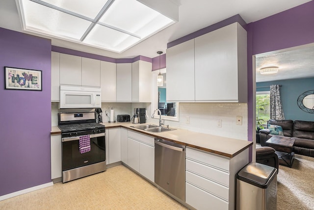 3923 Perry Ave SW, Wyoming, MI 49519 - kitchen featuring appliances with stainless steel finishes, tasteful backsplash, light countertops, and white cabinetry