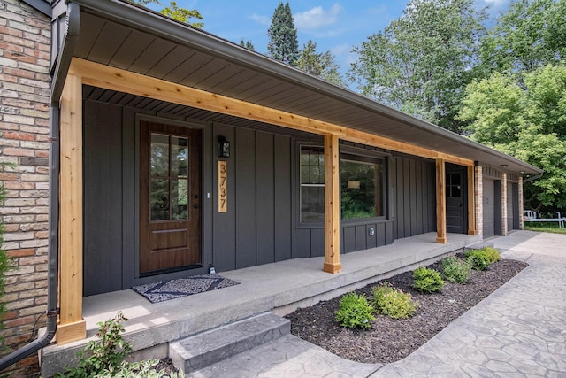 3737 Peach Ridge Ave NW, Grand Rapids, MI 49544 - doorway to property with a porch, board and batten siding, and a garage