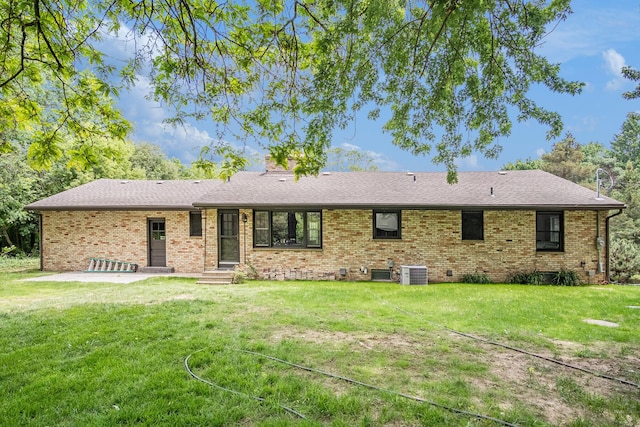 3737 Peach Ridge Ave NW, Grand Rapids, MI 49544 - rear view of house featuring brick siding, a lawn, a patio area, and a chimney