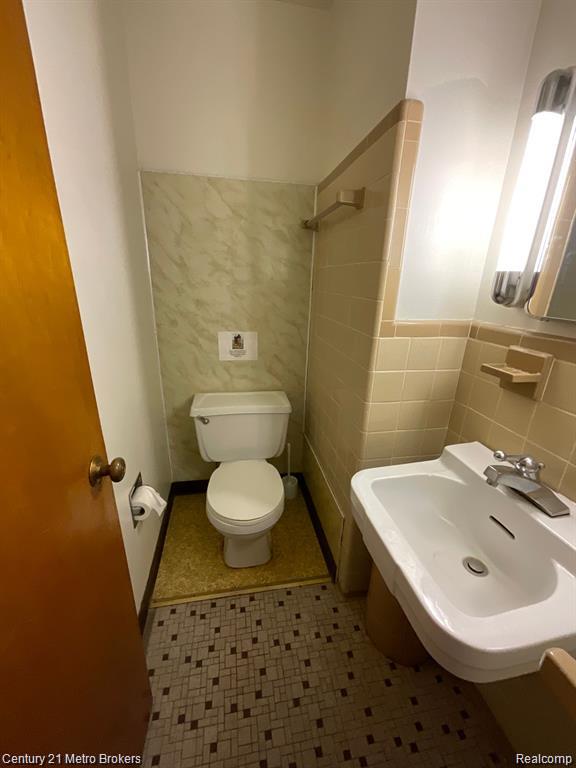 106 N Marquette St, Durand, MI 48429 - bathroom featuring tile walls, tile patterned floors, and wainscoting