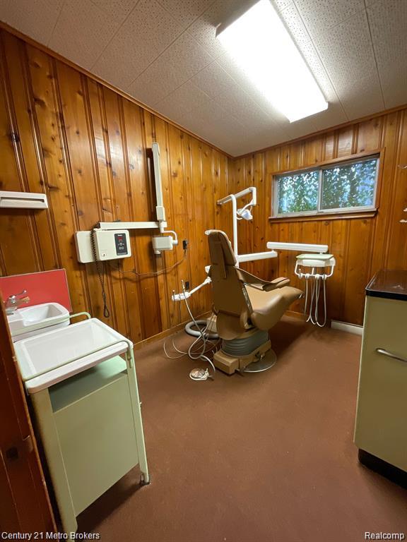 106 N Marquette St, Durand, MI 48429 - living area with wooden walls and carpet floors