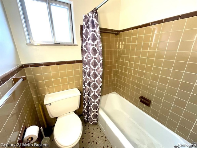106 N Marquette St, Durand, MI 48429 - full bathroom with tile walls, shower / bath combination with curtain, and wainscoting